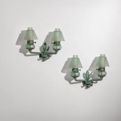 une paire d'appliques murales en verre vert fixées à un mur blanc