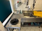une cuisine équipée d'un évier, d'une cuisinière et d'une poubelle