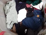 a pile of clothes sitting in a basket on the floor