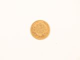 a close up of a gold coin on a white surface