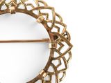 a gold brooch with a circular design on it