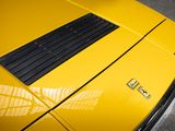 a close up of a yellow sports car parked in a parking lot