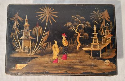 une boîte noire ornée d'une peinture, posée sur une table