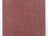an old book with a red cover sitting on a white surface