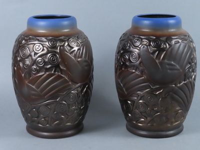 two brown vases with blue lids on a gray surface