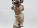 statue of a boy on a rock with a fish in his hand