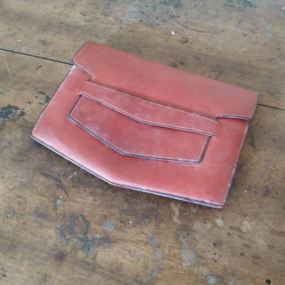 un portefeuille en cuir rouge posé sur une table en bois