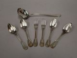 five spoons and a fork on a white table