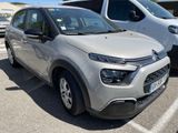 une Citroën argentée garée sur un parking à côté d'autres voitures