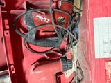 une boîte rouge contenant des outils, posée sur le sol