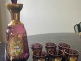 four shot glasses and a decanter on a table