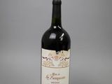 La bouteille de vin est posée sur la table, sur une surface grise.