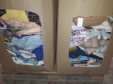 two open cardboard cabinets with clothes in them on the floor