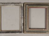 two silver picture frames on a white surface with a mirror in the background