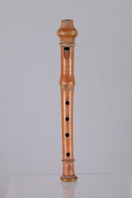 a wooden flute that is on display in a glass case