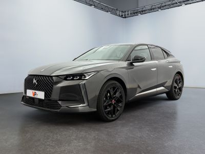 a grey car parked in a large room with a white wall