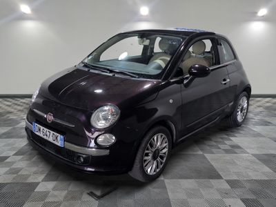 la photo d'une petite voiture noire sur un sol en damier
