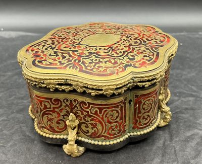 une boîte dorée et rouge posée sur une table