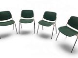 quatre chaises vertes sont disposées en cercle sur une surface blanche