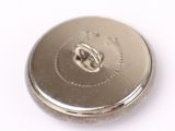 a close up of a silver button on a white surface