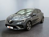 Une voiture grise est garée dans une pièce au sol noir.
