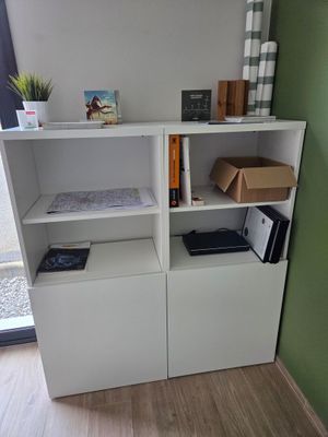 une étagère blanche sur laquelle sont posés plusieurs livres