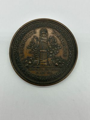 une image représentant une pièce de monnaie en bronze sur laquelle figure une tour horloge