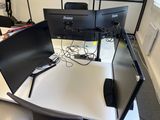 two computer monitors sitting on top of a white desk