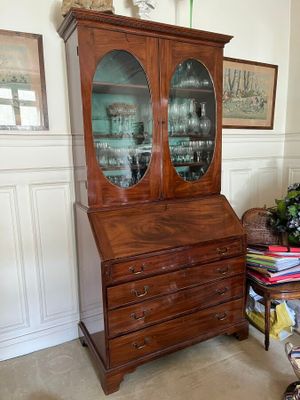 a wooden cabinet with a glass door in a room