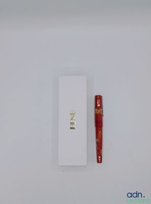 a red pen sitting on top of a white box next to a red pen