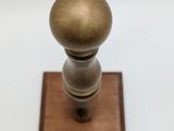 a wooden base with a metal knob on it
