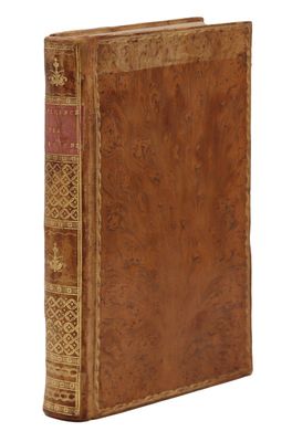 un vieux livre à la couverture brune posé sur une surface blanche