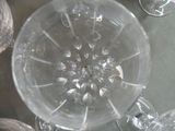 a glass of wine sitting on a table next to a bunch of wine glasses