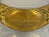 a gold plate with a plaque on it in a display case