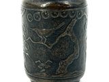a black vase with a dragon on it on a white surface