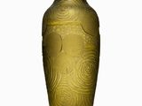 a gold vase that is sitting on a white surface