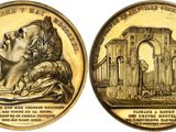 a close up of a coin with a statue on it