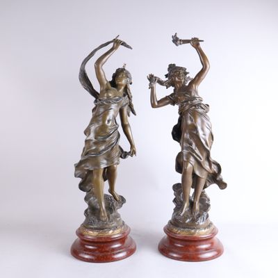 paire de statues en bronze représentant une femme et un oiseau, posées sur un socle en marbre