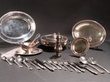 beaucoup d'objets en argent plaqué et d'argenterie sur une table