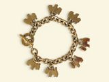 a gold bracelet with charms on it on a white background