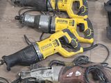 de nombreux outils électriques posés par terre les uns à côté des autres