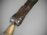 a close up of a bell with a leather sheath on it