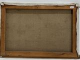 an old picture frame with a piece of fabric hanging on the wall