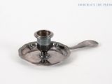 a silver candle holder with a spoon on it