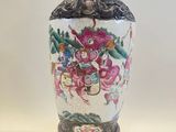 a vase with a painting on it sitting on a table