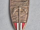 a close up of a metal badge with a sword on it