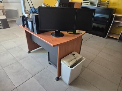 un bureau sur lequel sont posés deux écrans et une imprimante