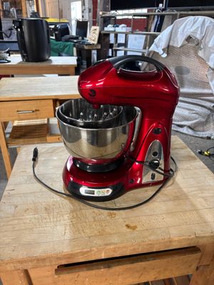 un mixeur rouge posé sur une table en bois