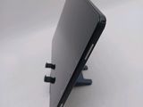 the back of a black laptop computer sitting on top of a white table
