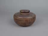 an old wooden bowl with a lid sitting on a table